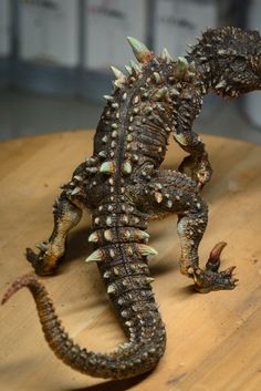 a small lizard sitting on top of a wooden table