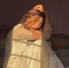 a woman with her hands on her head and arms behind her back as she poses for the camera