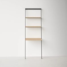 an empty shelf with three shelves on each side, against a white wall and floor