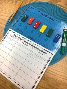 a roll and cover game with pencils next to it on a wooden table top