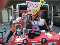 two people standing in front of a table with food on it and a sign that says diner eat