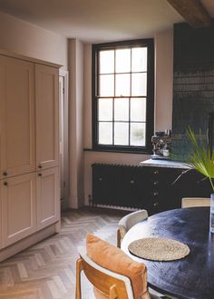 a dining room table and chairs in front of a window