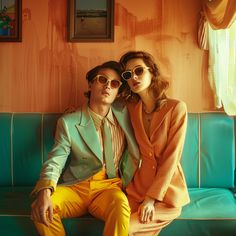 two people sitting on a couch wearing sunglasses