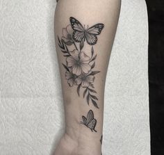 a woman's arm with butterflies and flowers tattooed on the left side of her leg