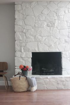 a living room with a fireplace, chair and basket