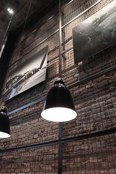 two lamps hanging from the side of a brick wall