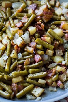 a white plate topped with green beans and potatoes