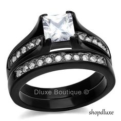 two black wedding rings with white diamonds on each one and an engagement ring in the middle