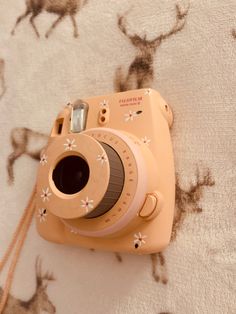 an orange camera sitting on top of a bed