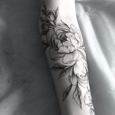 a black and white flower tattoo on the arm