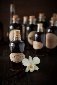 bottles of vanilla syrup and a flower on a table