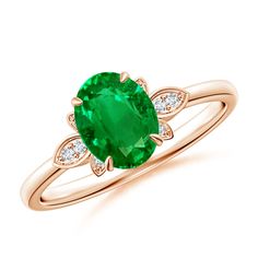 an oval emerald and diamond ring on a white background