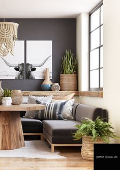 a living room filled with furniture and paintings on the wall next to a wooden table