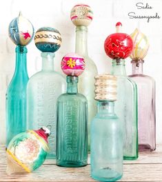 there are many different colored glass bottles on the table