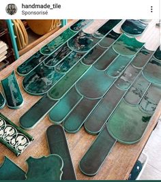 several pieces of green glass sitting on top of a wooden table next to other items