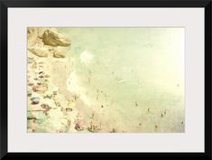 an aerial view of a beach with people on the sand and in the water, framed art print