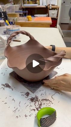 a person is making a vase out of clay