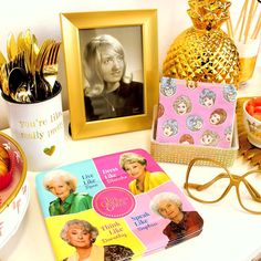 a table topped with pictures and other items next to a gold pineapple, candy