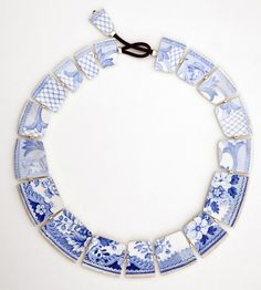 a blue and white necklace is hanging on the wall