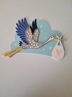 a stork with a baby in it's belly is hanging on the wall