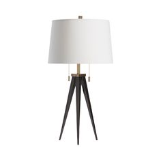 a table lamp with a white shade on it and a black wooden tripod base