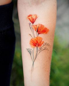 an orange flower tattoo on the arm