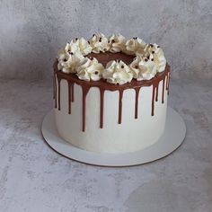 a white cake with chocolate and whipped cream drizzled on top