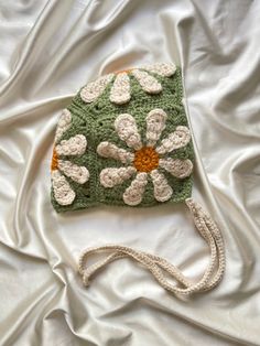 a crocheted purse sitting on top of a white sheet