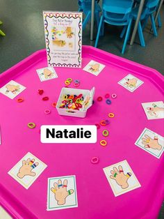 a pink table topped with lots of cards and toys