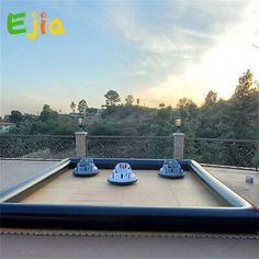 an inflatable air bed on the roof of a building with trees in the background