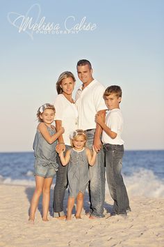 a family posing for a photo on the beach