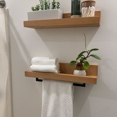 two wooden shelves with towels and plants on them