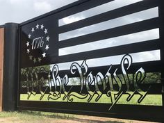 an american flag painted on the side of a black fence with graffiti written in it