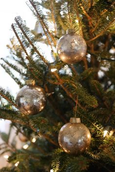 three ornaments hanging from the top of a christmas tree