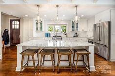 a kitchen with an island and three stools