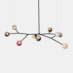 a chandelier with different colored balls hanging from it's center, on a white background