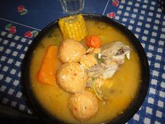 a bowl filled with soup and vegetables on top of a table