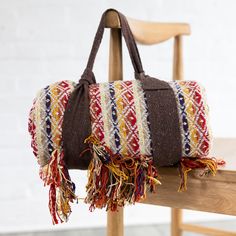 a multicolored bag sitting on top of a wooden chair