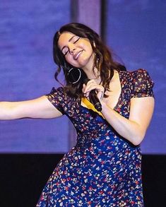 a woman holding a microphone in her right hand