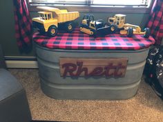 toy trucks are sitting on top of an inflatable storage container with the word rhett