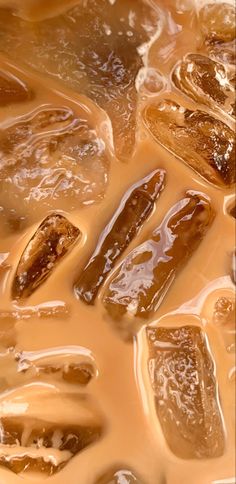 brown liquid flowing over ice cubes on top of each other