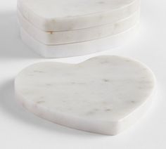 two white marble heart shaped boxes sitting on top of each other in front of a white background