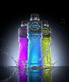 three different colored water bottles with splashing water around them on a reflective surface, in front of a black background