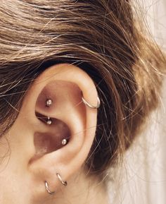 a woman wearing gold ear piercings on her left ear