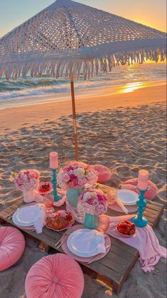 a table set up on the beach at sunset