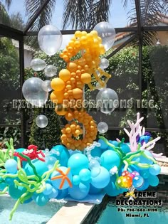 balloons floating in the air next to a pool with an octopus and starfish decoration