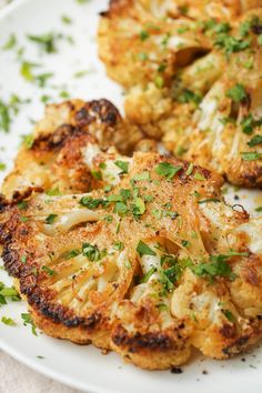 roasted cauliflower steaks on a plate with parsley sprinkled on top