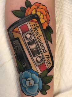 a tattoo with an old school cassette and flowers on it