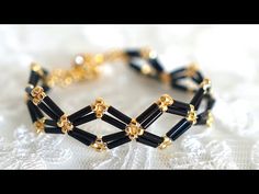 black and gold beaded bracelet on white lace with beads in the shape of hexagons