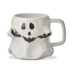 a white coffee mug decorated like a ghost